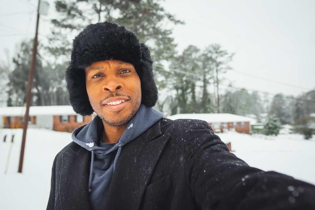 man taking selfie in fur hat